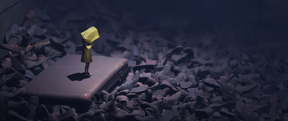 A small child in a yellow rain coat stands on a piece of luggage amid a sea of shoes. This is a still from the game Little Nightmares.