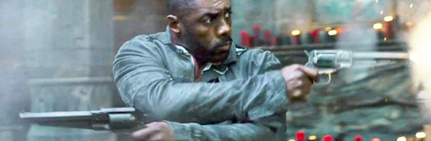 Idris Elba shooting two hanguns in opposite direction with his arms crossed. This is a still from the movie the Dark Tower. 