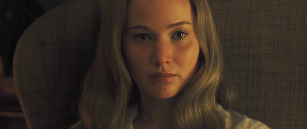 Jennifer Lawrence, long blonde hair hanging around her face, stares directly to camera in this still from mother!