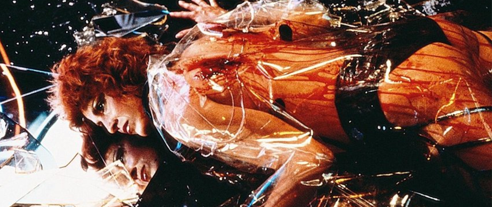 A womans body, in a transparent jacket and black underwear, covered in blood. This is a still from Blade Runner.