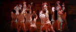 Several figures stand holding their arms out. A still from the musical Hamilton.