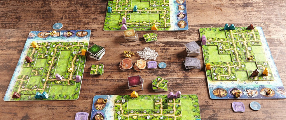 A series of green board games spread over a brown tabletop. This is a picture of the game Kabura.