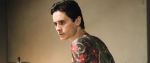 Jared Leto, with his android face and a back full of Japanese style tattoos, peers off in the middle distance slightly over one shoulder.