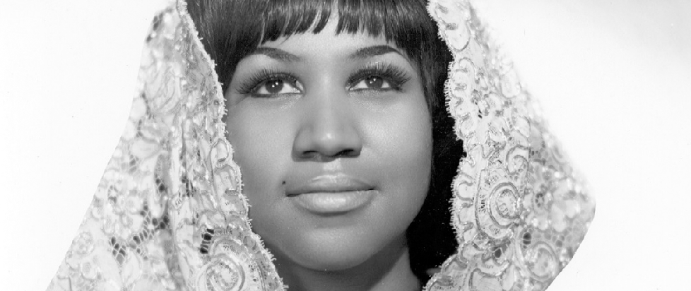 a young Aretha Franklin, her face beautific, hair covered in a lace shawl.