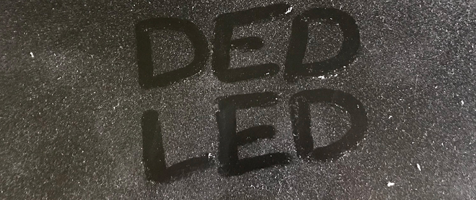 a dusty screen with finger tip spelled letters "DED LED"