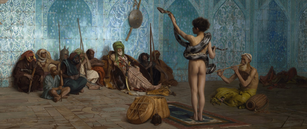 A naked person holds a tamed snake up for entertainment.