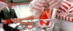 Goldie Hawn in Overboard, laying on a deck chair in a red swim suit with one foot up in the lap of a man who is doing her toenails.