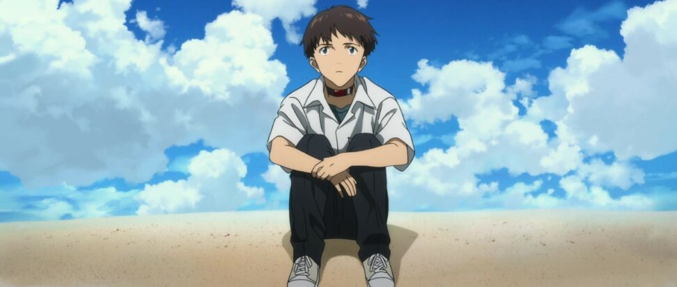 An animated boy sits on the beach, backed by a bright blue sky with white fluffy clouds.