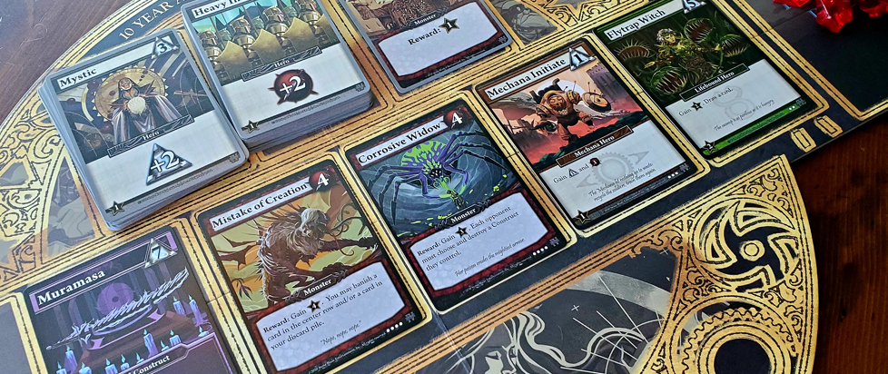 A series of cards from the deck building game Ascension laid out on a deck mat.