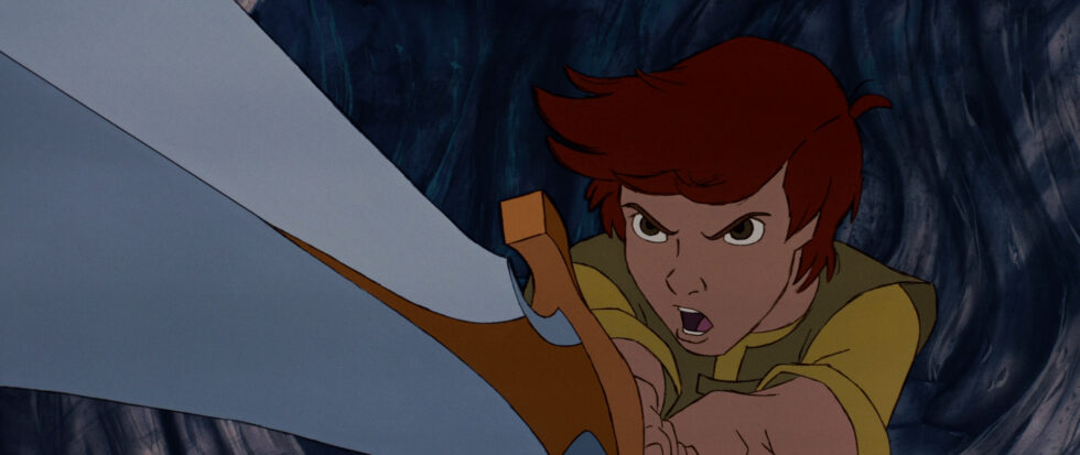 A boy holds a sword in front him, a fierce look in his eyes.