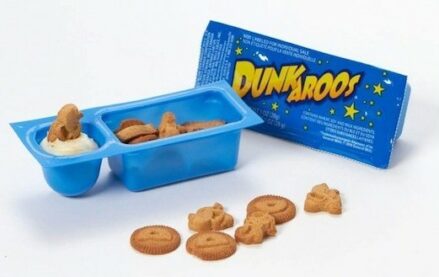 A two-compartment Dunkaroos package, showing vanilla cookies in the large compartment and sticky vanilla frosting in the smaller one.