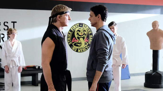 Two middle-aged men face off in a karate dojo.