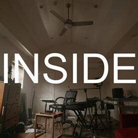 The cover to Bo Burnham's "Inside." An artful photograph shows an empty, homemade recording studio set up in a small room of a suburban house. The word "Inside" is superimposed on top.