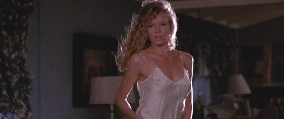 Kim Basinger in a white shift with her hair blown back sexily