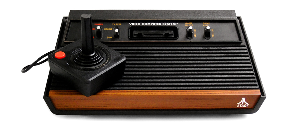 An Atari videogame console with wood-grain detailing on the front panel. Includes joystick.