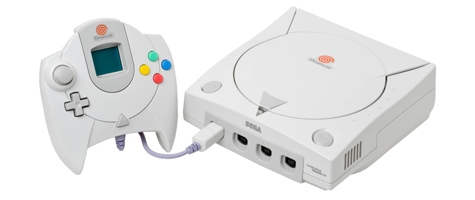 A white plastic Sega Dreamcast videogame console. The large controller features a small LCD screen and four brightly colored buttons in red, yellow, blue and green.