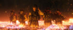 Five soldiers in heavy gear and camouflage fatigues wade through what looks like a pool of fiery lava.
