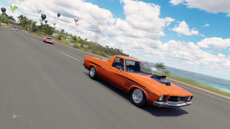An orange Ford mustang races down a beach-side speedway. Several hot-air balloons float in the far distance.