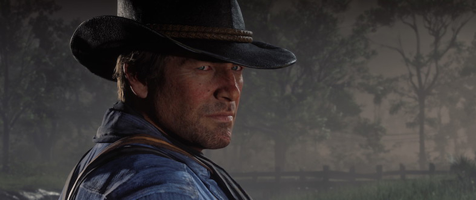 A close-up of Arthur Morgan, the protagonist of the videogame Red Dead Redemption 2. He is a brunette white man with a five o'clock shadow. He wears a chambray shirt with suspenders and a black Stetson hat with brown braided leather trim.