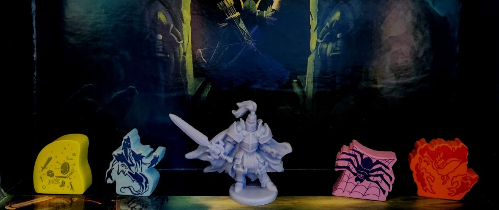 Five miniatures from Tiny Epic Dungeons stand at the ready, featuring skeleton, ghost, knight, spider in web, and fire elemental