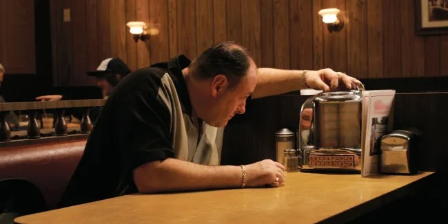 A still from the final episode of The Sopranos, in which Tony Soprano is seen choosing a song from a small jukebox set on a diner table.