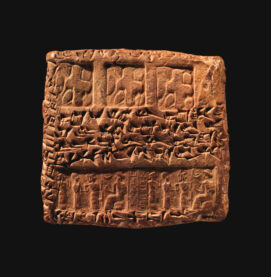 A clay tablet marked with ancient writing and artwork.