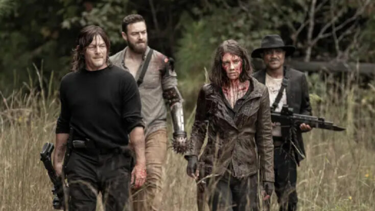 In a still from The Walking Dead, four major characters walk through a post-apocalyptic wilderness, bloodied and carrying various weapons.