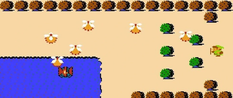 A screenshot from the overworld of The Legend of Zelda showing pixellated brush and the corner of a large blue lake. Several menacing creatures patrol land and water.