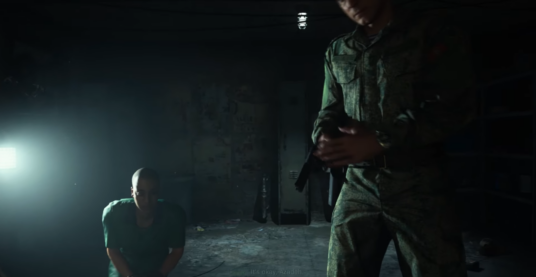 The last screenshot from Modern Warfare, where this time the agent torturing the player threatens their female compatriot with a gun as she cowers in the dim room
