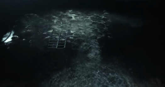 Screenshot from the torture scene in Modern Warfare, a flow of water on the floor down into the drain, the runoff from some waterboarding