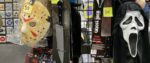 Several monstrous costume pieces hanging in a booth at New York Comicon, including masks for Scream's Ghostface and Jason's hockey mask from the Friday the 13th franchise.