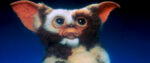 The mogwai Gizmo, from the movie Gremlins, with an exaggeratedly sad frown on his face. He's furry with enormous ears and eyes, the definition of "weird but cute."
