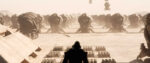 A scene from Dune shows the silhouette of a man looking out across a vast expanse of organized troops in a desert landscape.