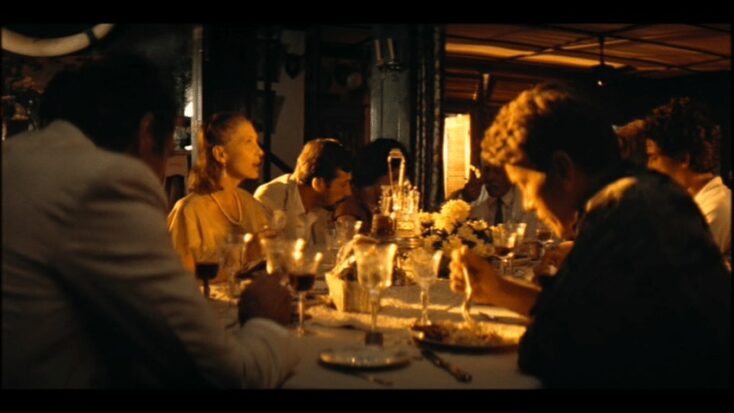 Dinner at the plantation dinner table as lit by sickly late-afternoon sun.