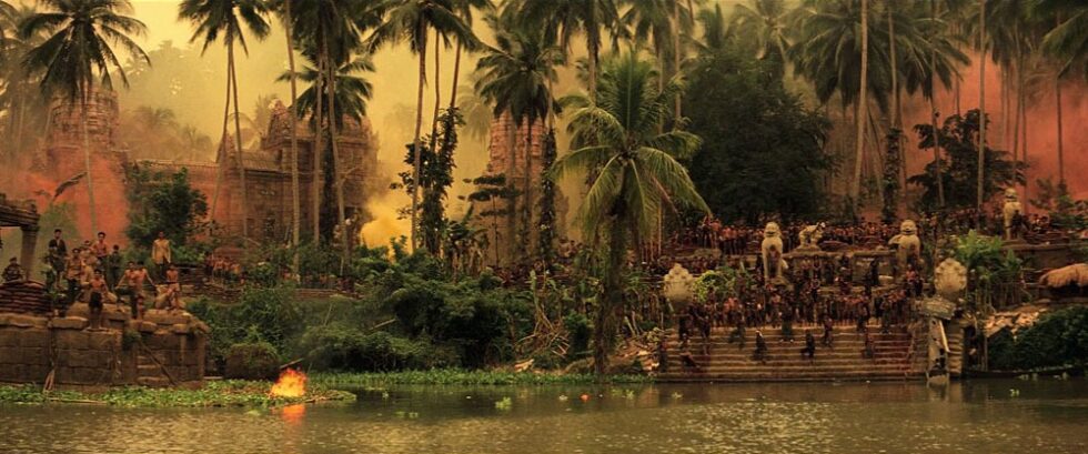 A Cambodian riverbank as seen in Apocalypse Now. The air seems hazy with smoke.