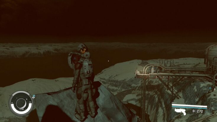 A lonely spacefarer looks out at the horizon of a dark and rocky planet in a screensho from Starfield.