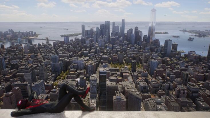 Miles Morales lounges on top of a New York City skyscraper, the rest of Manhattan stretching below him into the distance.
