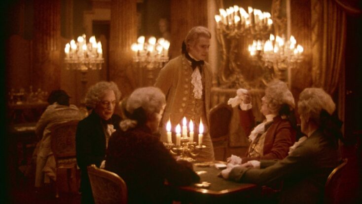 A scene from Barry Lyndon shows the titular character conversing with several other bewigged men at a candlelit table.