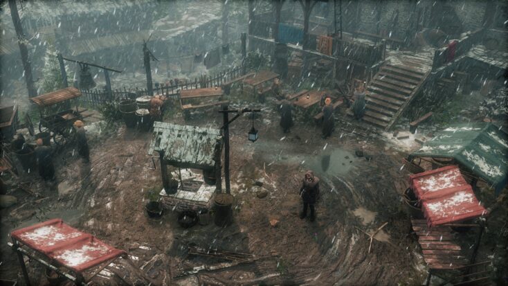 Wiktor stands in an open market space surrounded by several wooden stalls. A light snow falls from the sky.