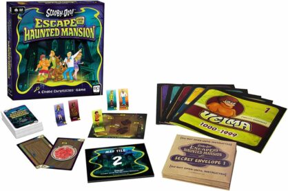 A picture of the box for Scooby Doo Escape from the Haunted Mansion, as well as the character standees, a deck of cards, a little map tile, another one with a number on it, booklets for every character, and secret envelopes as well
