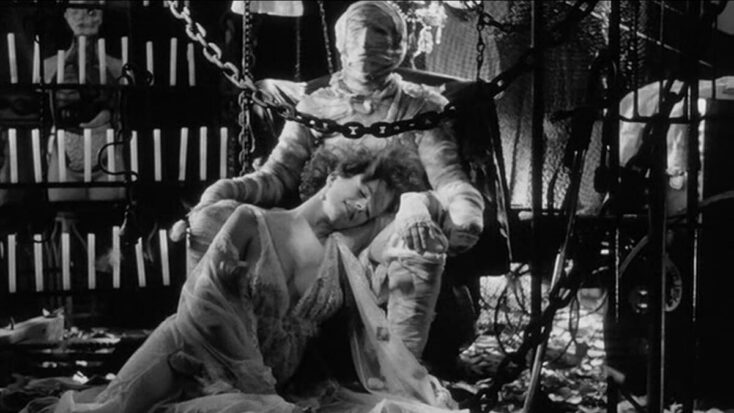Another still from Singapore Sling shows a young woman resting her head in the lap of a person wrapped head-to-toe in bandages like a mummy.