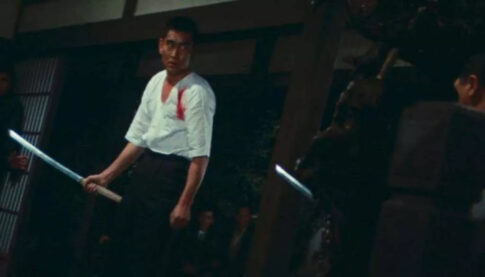 Another Abashiri Prison movie still, this time with a wounded Yakuza warrior holding a katana and facing off an opponent nearby 