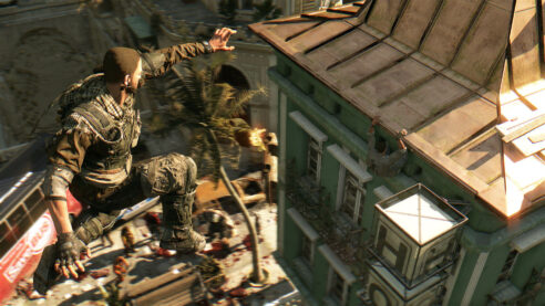 Screenshot of Dying Light where the main character in camo gear is jumping to a rooftop over palm trees and hordes of zombies