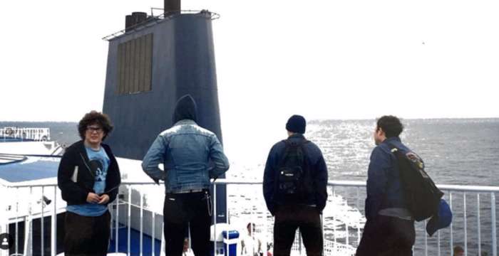 In a photo that could be either an album cover or a slide from a vacation carousel, the band Orchid looks across the sea from the observation deck of a partially submerged submarine.