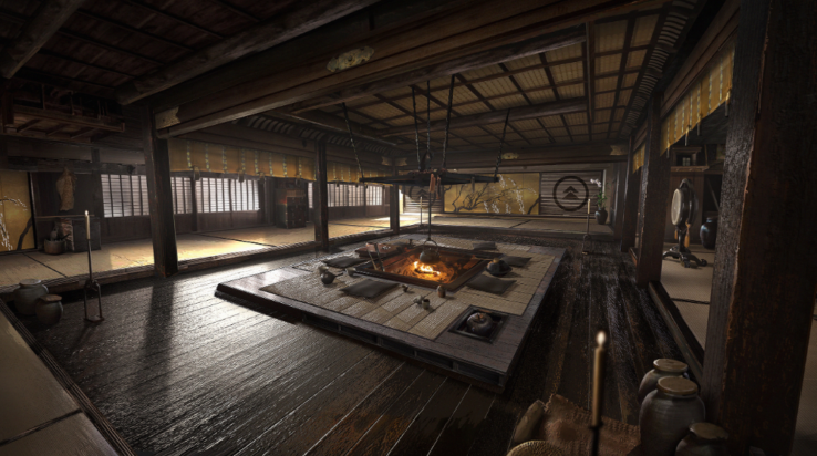 A screenshot from Ghost of Tsushima shows the interior of a large room, a warm fire glowing in the hearth in the center of the floor.
