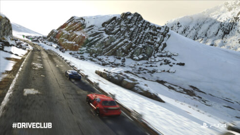 A screenshot of Driveclub with two cars flying down a mountain road with the hills covered in snow