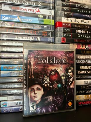 PlayStation games are neatly stacked on top of each other in two tall stacks. The game case for Folklore has been pulled out and is featured prominently.