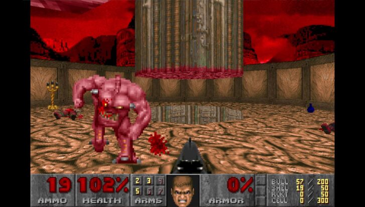 A hulking Pinky demon charges towards the player across a burnt hellscape in a screenshot from DOOM.
