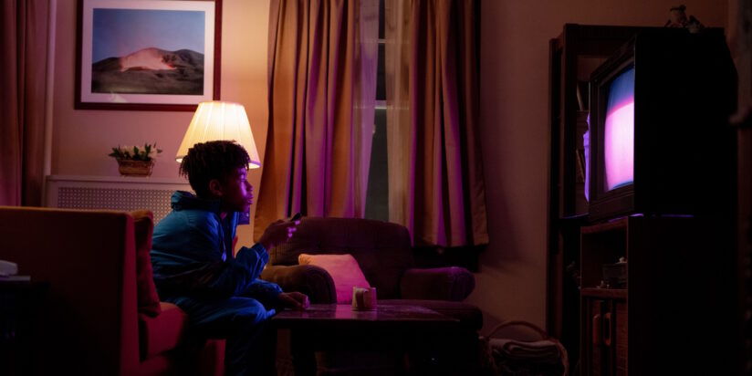 Owen, the young protagonist in I Saw the TV Glow, stares rapt at a TV screen in a darkened living room.