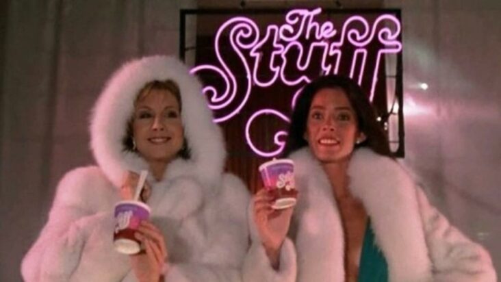 A still from The Stuff shows two models in luxurious fur coats holding containers of the eponymous product, clearly hawking the... stuff.
